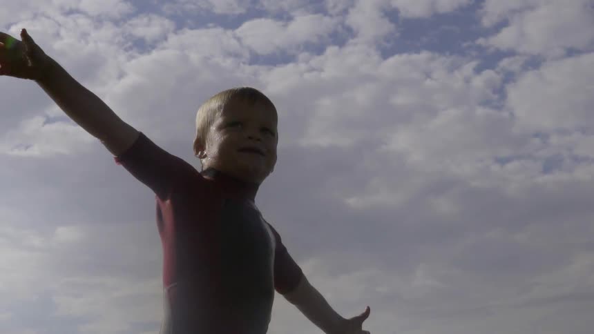 Child Walking Along the Bright Sandy Beach, Exploring Waves With Innocent Curiosity.