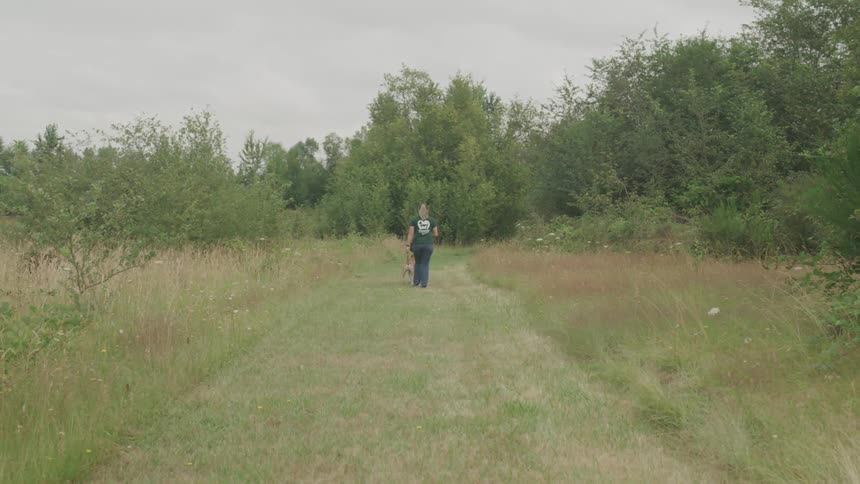 A woman walking a walk through a field