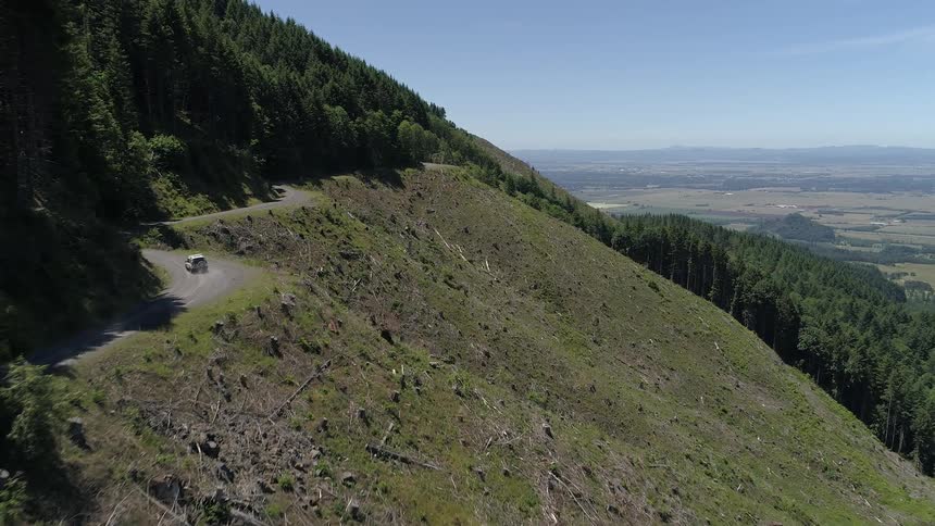 Car drives along winding road on side of mountain