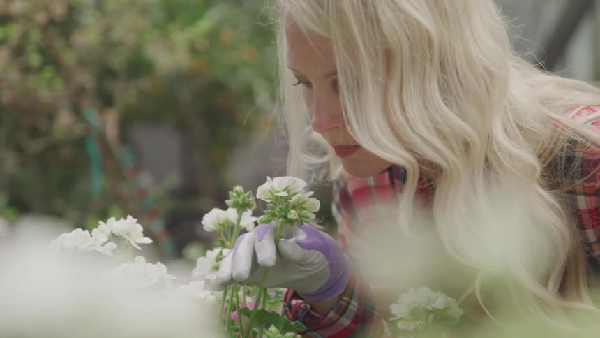 A woman leans in to smell a bunch of flowers