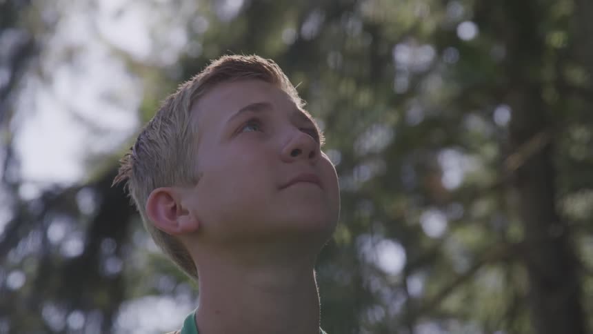 A young boy looks up towards the sky