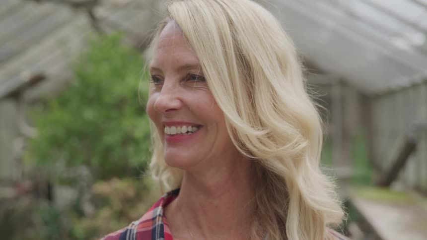 Mature woman on greenhouse smiling
