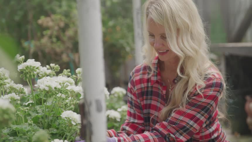 A woman sits and tends to her flowers