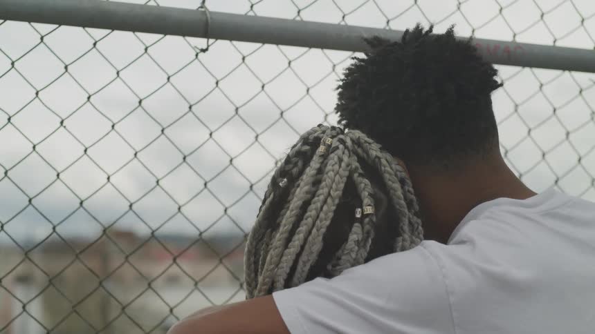 A young man puts his arm around a young woman