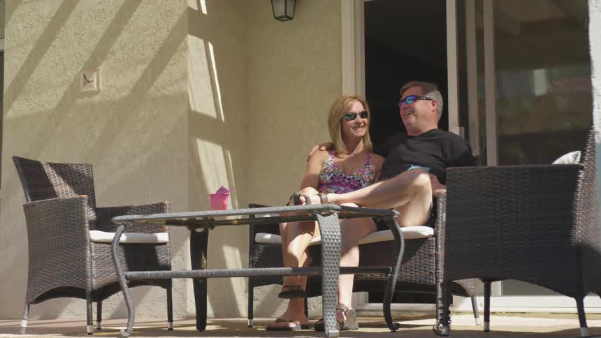 A couple sitting on a patio couch