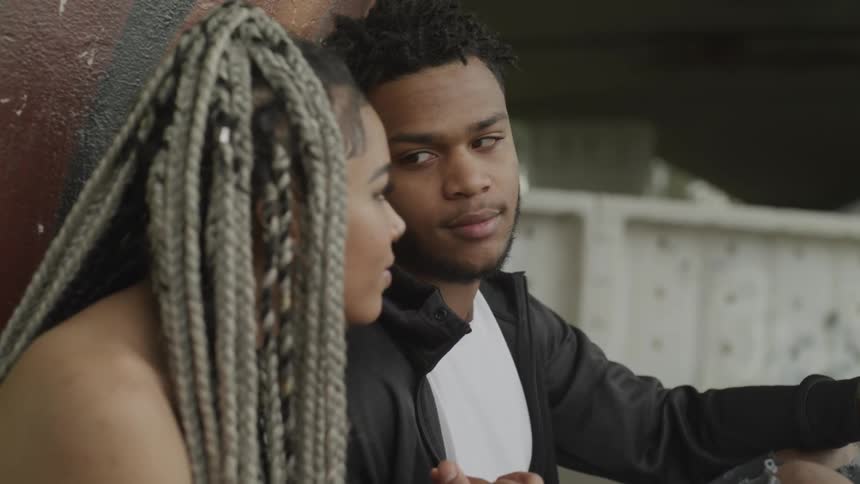 A man and a woman sitting next to each other outside