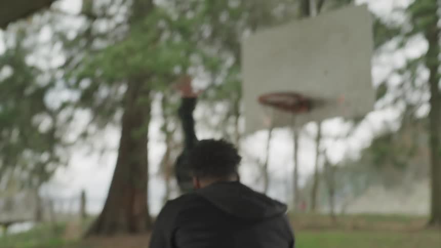Boy and girl playing basketball in the park