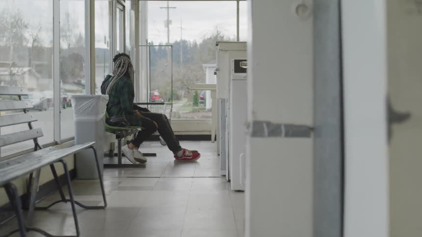 Black man and woman sit on the chair and have a conversation indoors during daylight