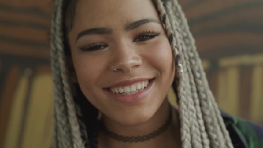 Woman in dreadlocks smiles at camera