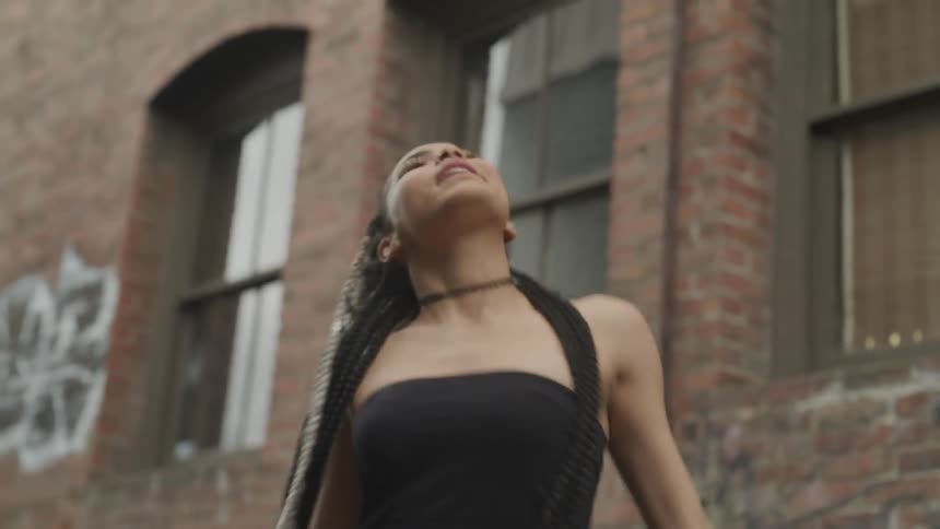 A young woman twirling in an alleyway