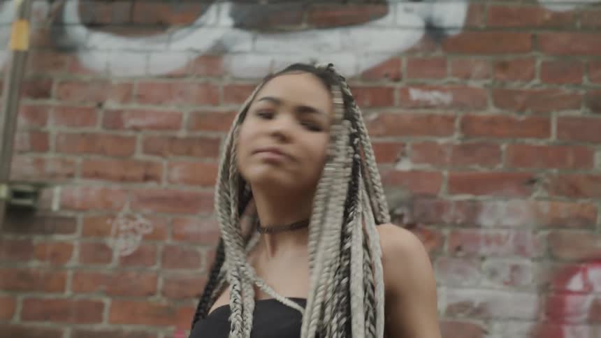 A young black woman with braids dances