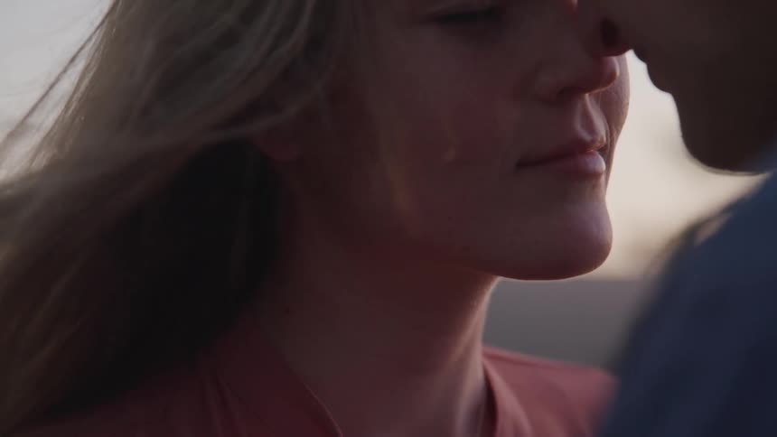 Man and woman stand with their noses touching