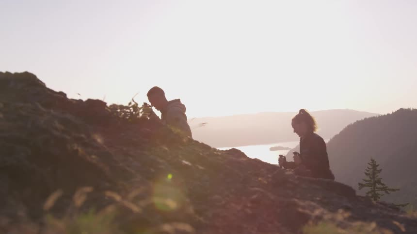 A man and woman hike up a hill