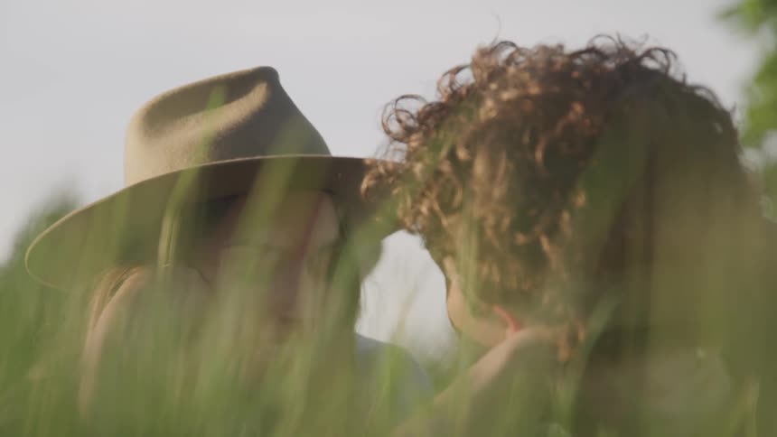 A man and woman lay together in the grass