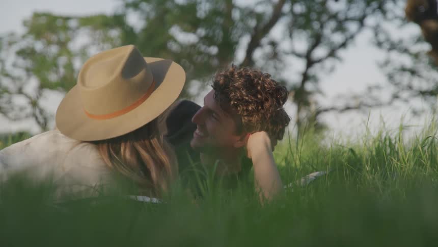 A couple kissing in the middle of a park