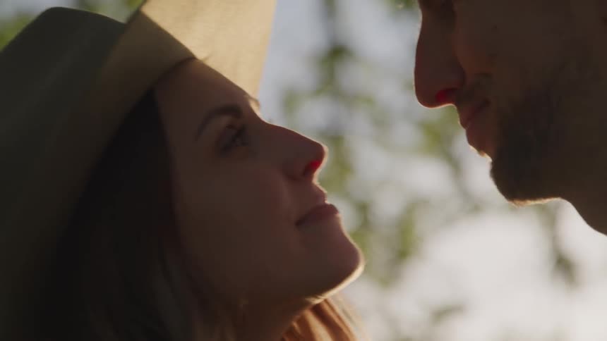 A man and woman lean in close together and touch noses