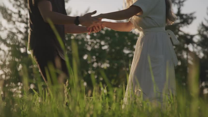 Man and woman embrace and dance in a field