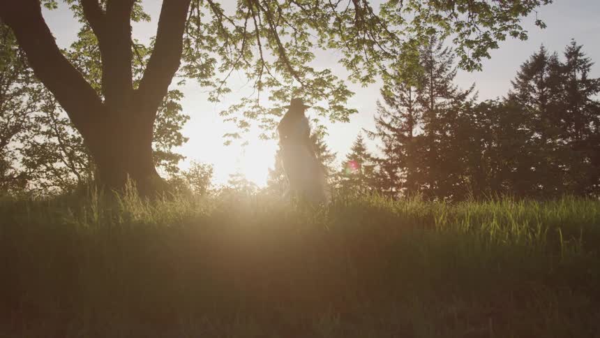 Girl standing under a tree in the sunlight