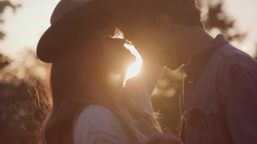 Man and a woman stand outdoors holding hands