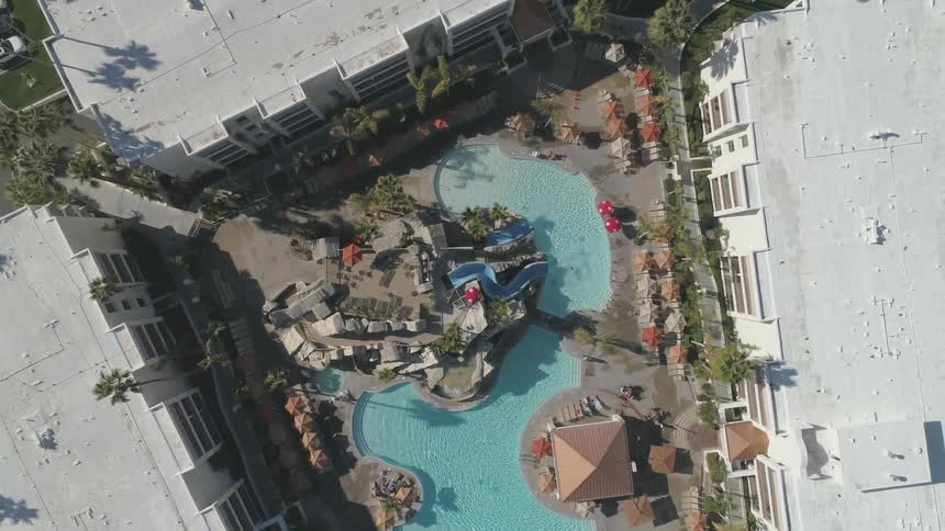 Birds eye view of a building with a swimming pool in the courtyard