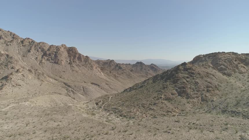 A desert with a mountain ridge and the sky in the background