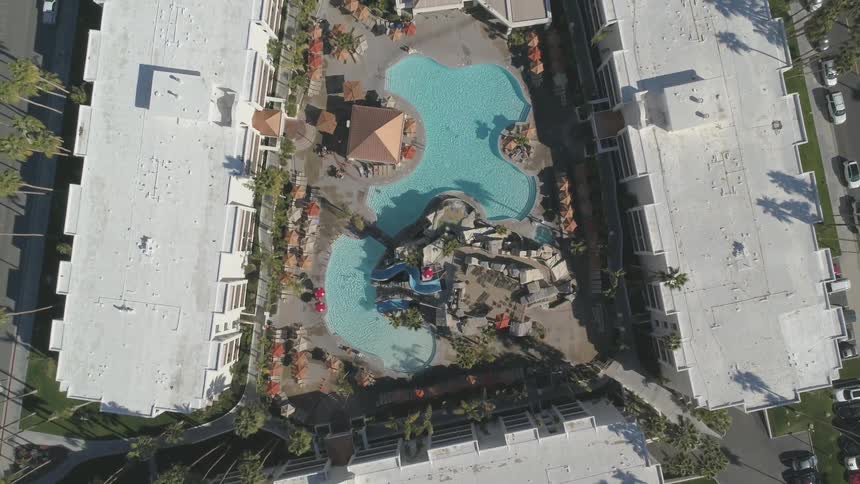 A pool sits in the middle of three large buildings