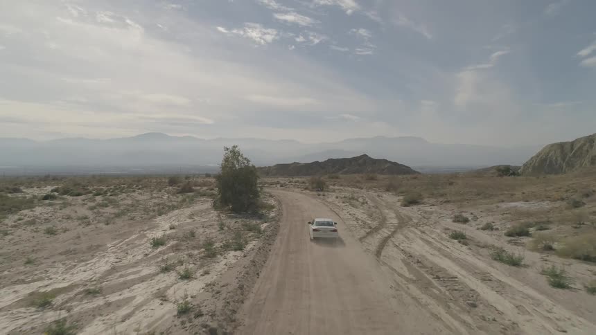 Car goes down on dirt road during daylight