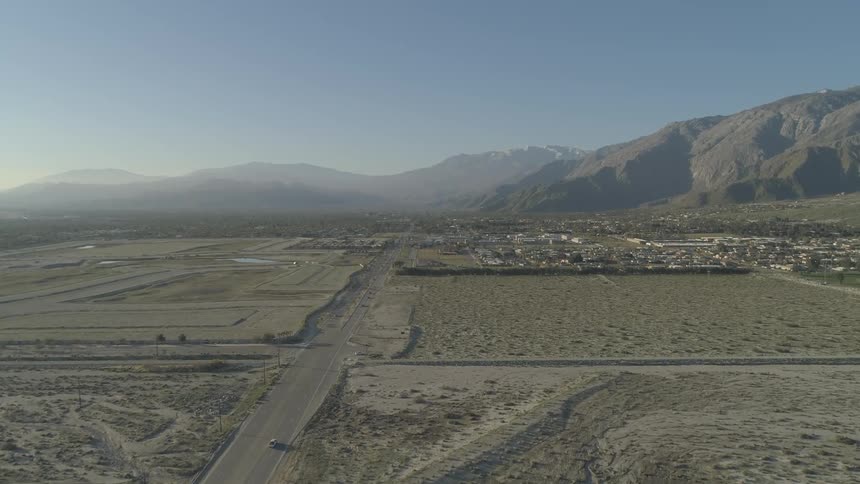 A street running through the desert near a town