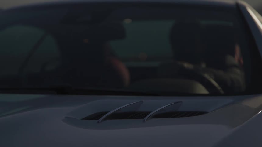 Man driving a car at night under street lights
