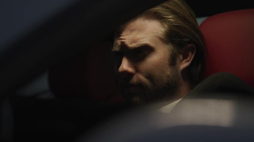 Blonde man drives sports car at night