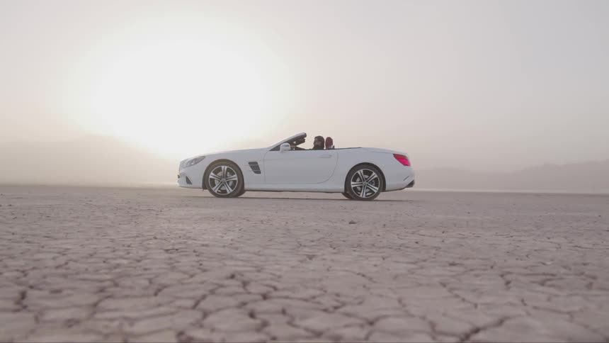 A man sitting in the car with the top down in the desert