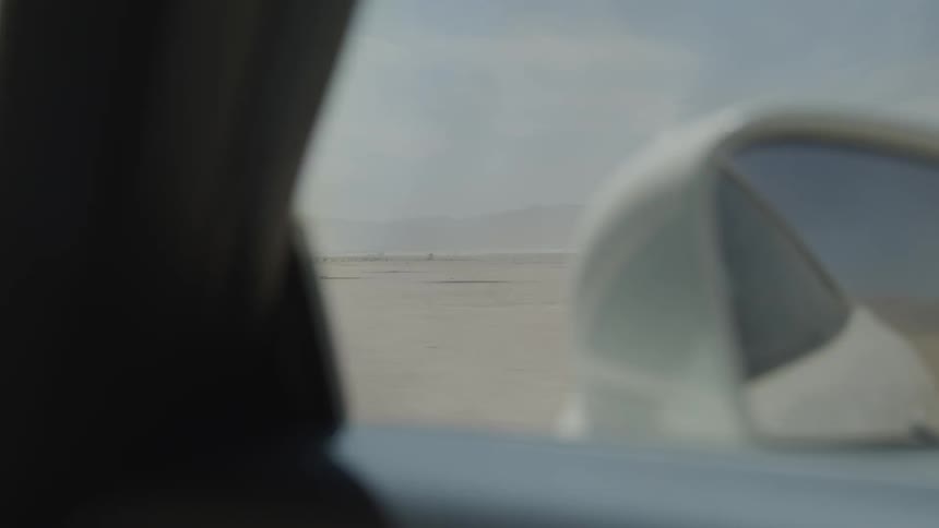 A car travels across sand in a desert
