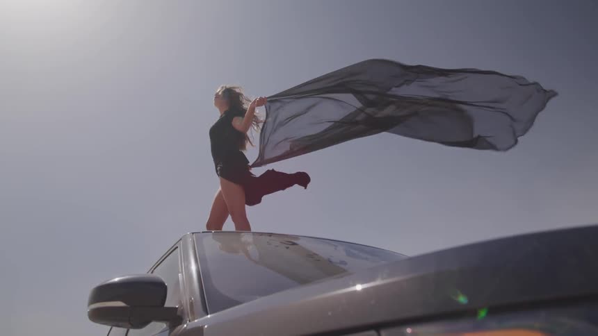 A woman is standing on top of a truck