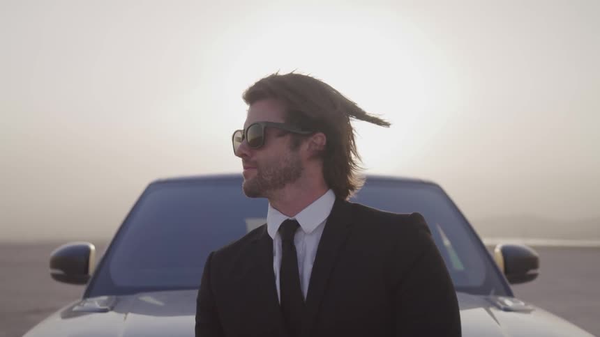 Man leaning against a car in the desert