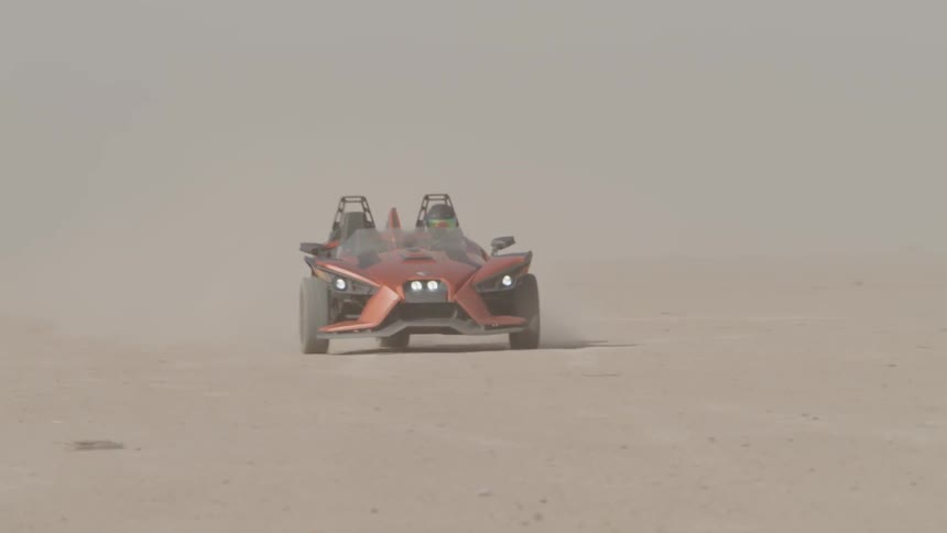 A person drives a dune buggy through the sand