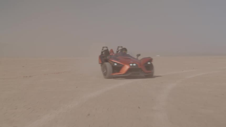A car is driving in a desert area