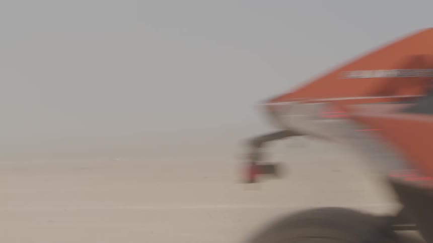 A man races his four wheeler in the desert