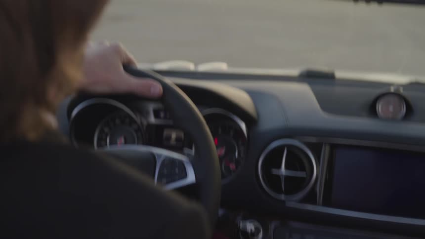 Man driving sports car through desert
