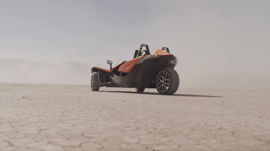 A motor vehicle sits on a dry lake bed
