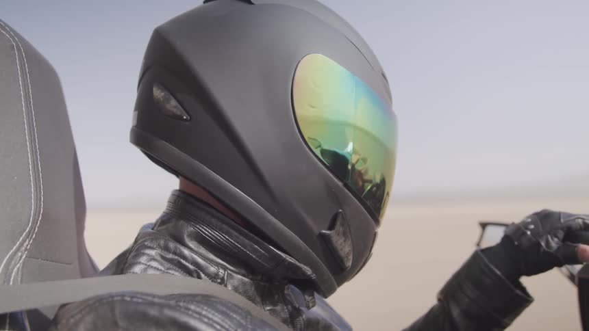 A person is driving a motorcycle in a desert area