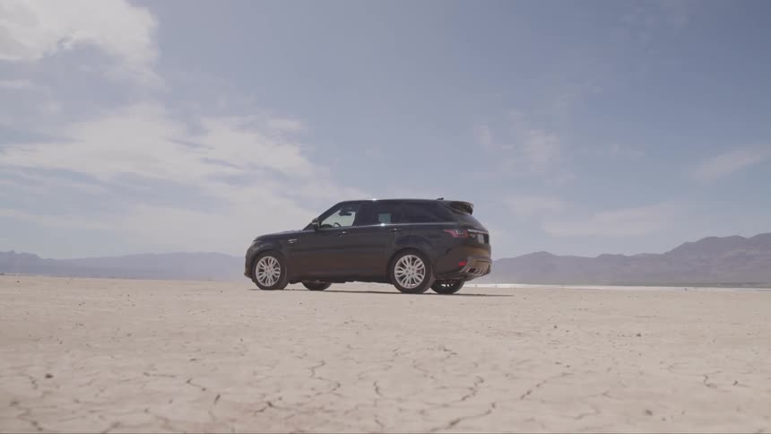 A vehicle sits in a large open desert
