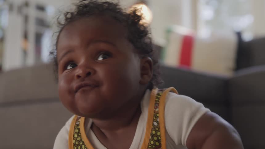 A toddler smile happily in the house