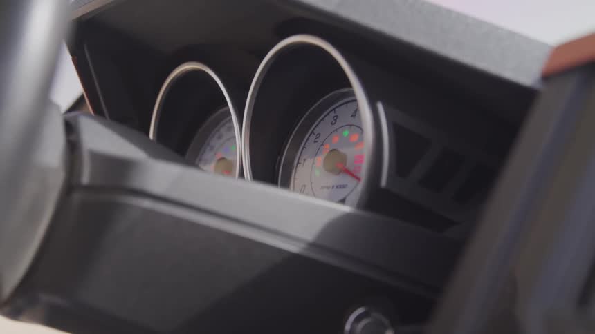 The drivers turns the key ignition to start a car