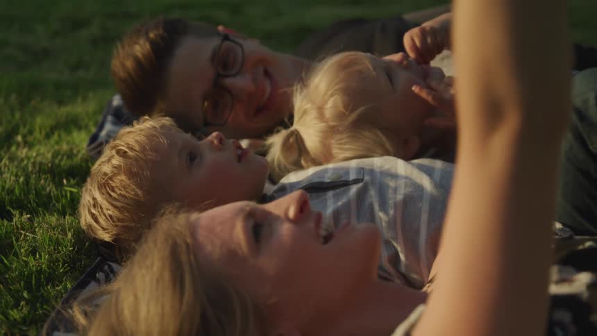 Family laying on a blanket outside