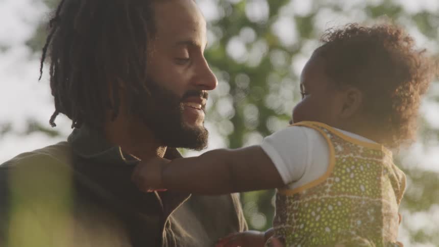 A man kisses and laughs with a happy baby