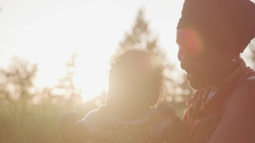 A young woman holds a baby