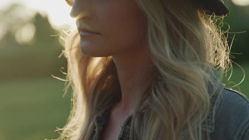 A woman stands in front of the sun