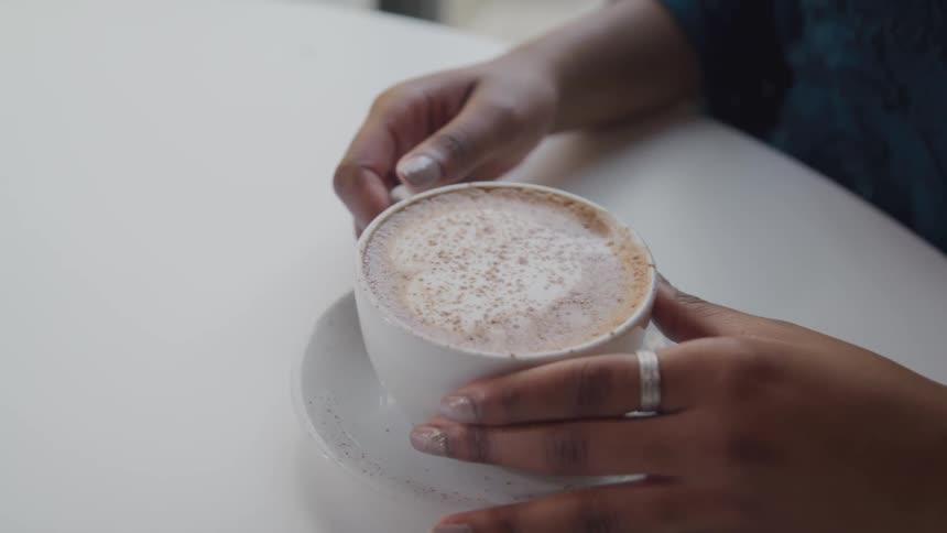 Woman holds hot drink with foam