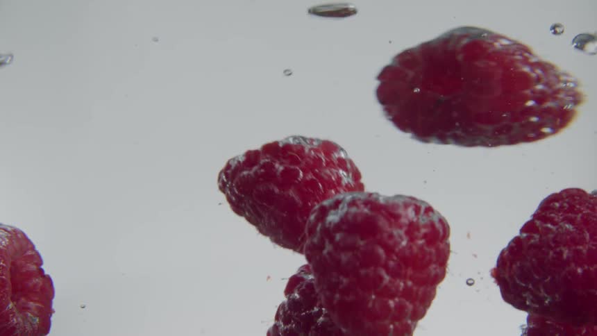 Raspberries being dropped into water