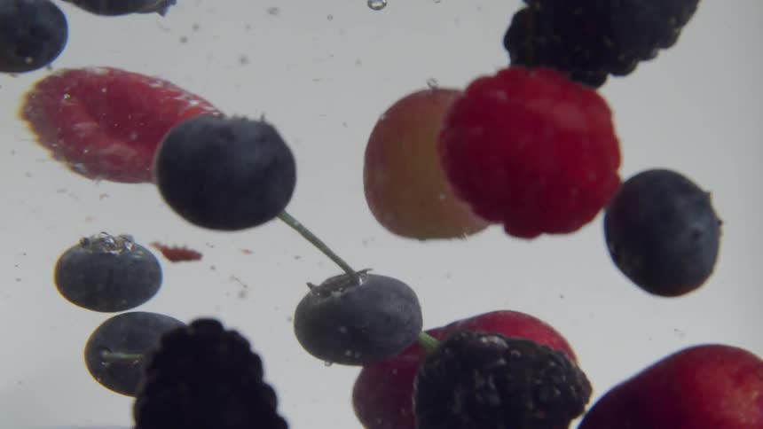 Raspberries blueberries blackberries and cherries floating in liquid